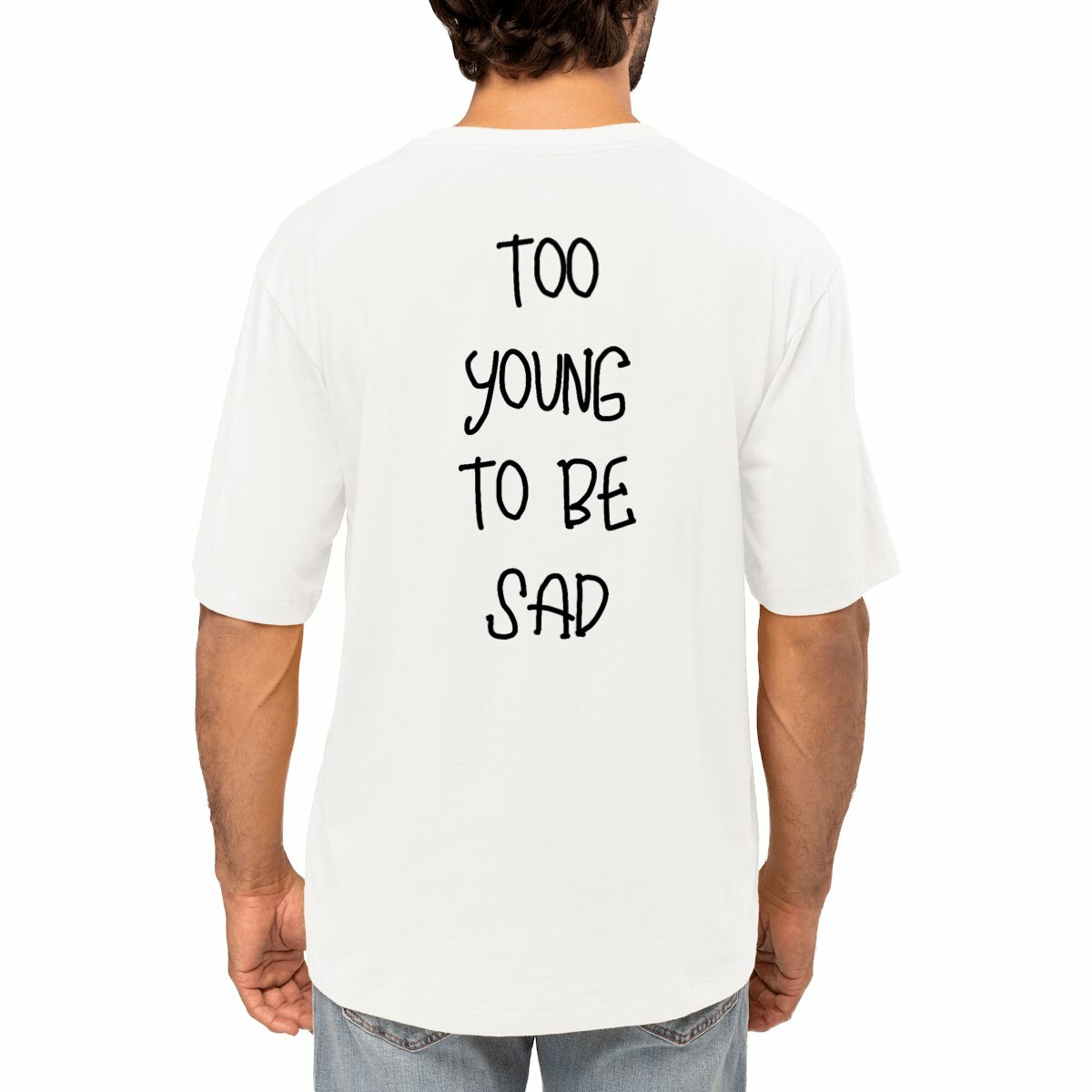 T-shirt blanc porté, avec l'inscription "Too Young to Be Sad" imprimée en noir sur le dos, style oversize et moderne.