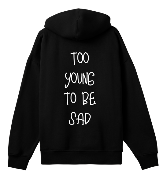 Hoodie noir Soy Amor vu de dos, avec l’inscription blanche “TOO YOUNG TO BE SAD” imprimée verticalement au centre.