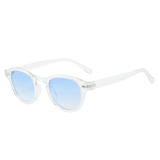 Lunettes de soleil transparent modèle Horizon de la collection MILO avec monture épaisse en plastique et verres teintés bleu, dotées de petites décorations en forme de triangle métallique au niveau des charnières."