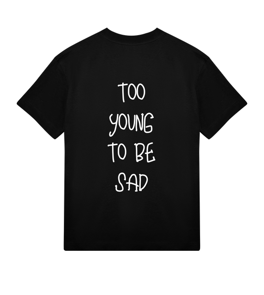 T-shirt noir Soy Amor vu de dos avec l’inscription blanche verticale “Too Young To Be Sad” imprimée au centre.