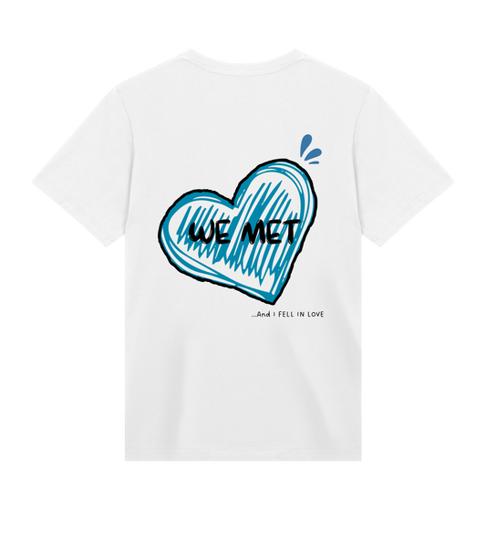 T-shirt blanc Soy Amor vu de dos avec un grand cœur bleu dessiné au trait, l’inscription “WE MET” au centre et la phrase “…and I fell in love” écrite en bas.